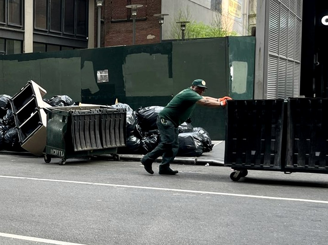 Junk removal worker moving a debris container
